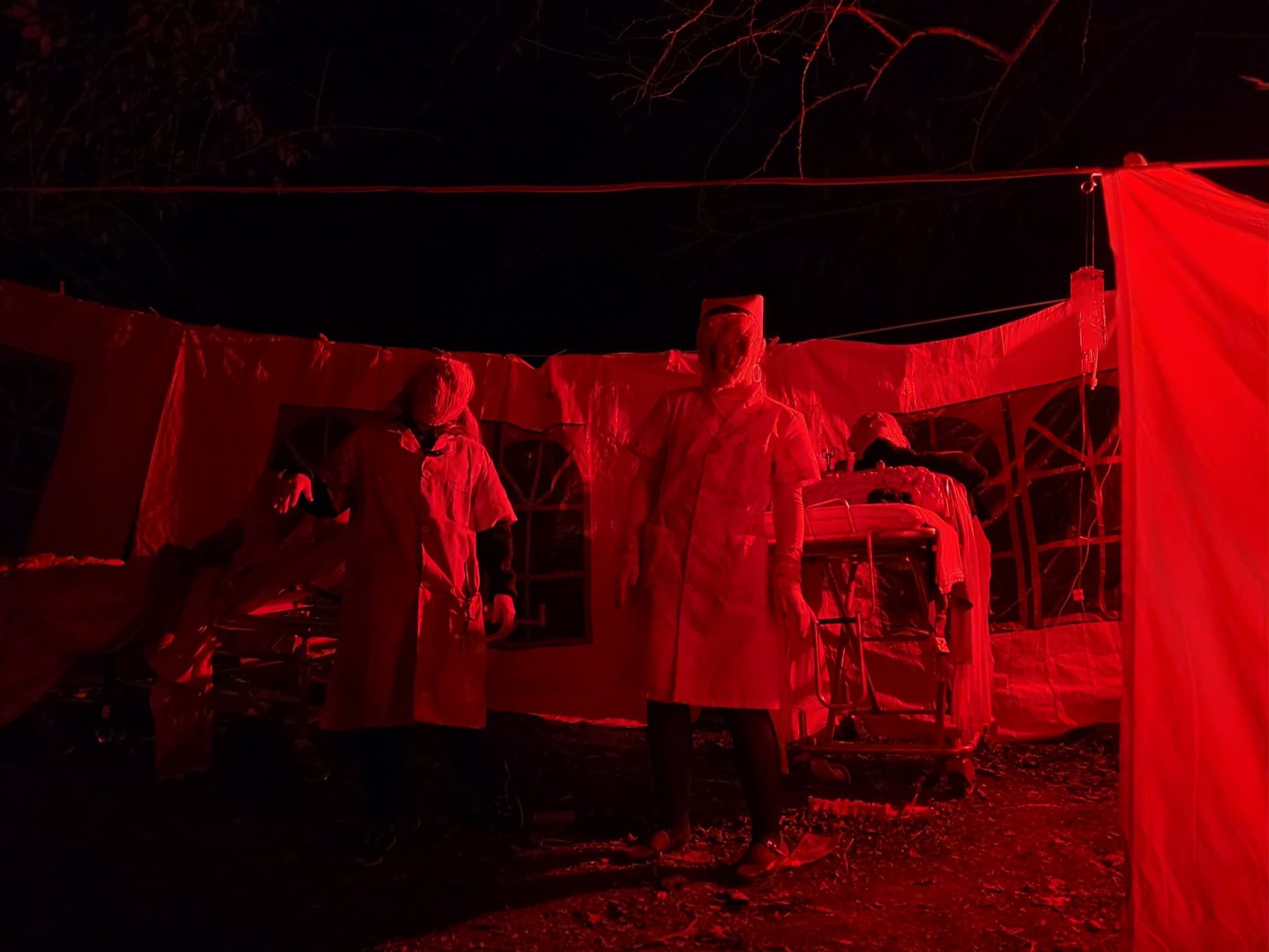 The field infirmary scene — masked nurses under blood-red light at Haunted Holler, Flemingsburg KY
